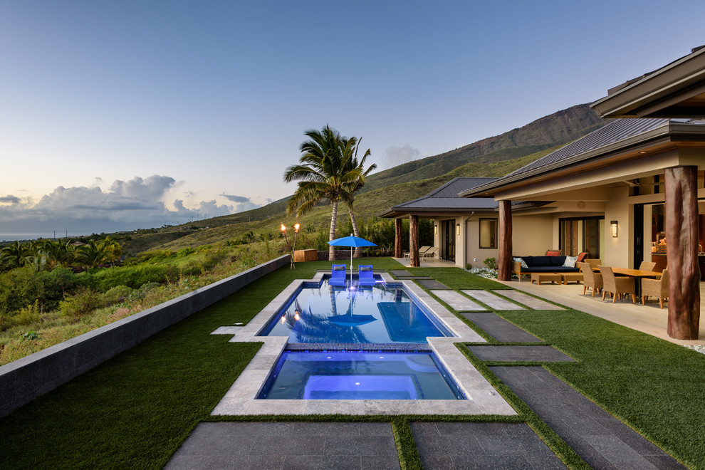 Immagine di una piscina monocorsia tropicale personalizzata dietro casa con una vasca idromassaggio
