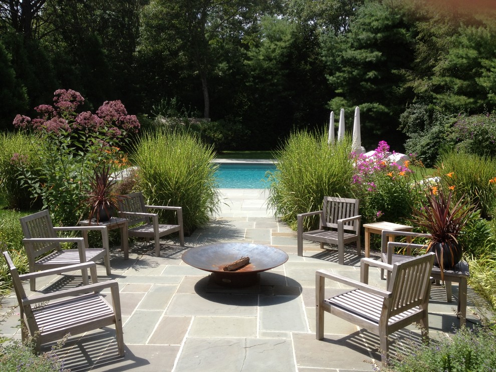 Example of a mid-sized trendy backyard stone and rectangular pool design in New York
