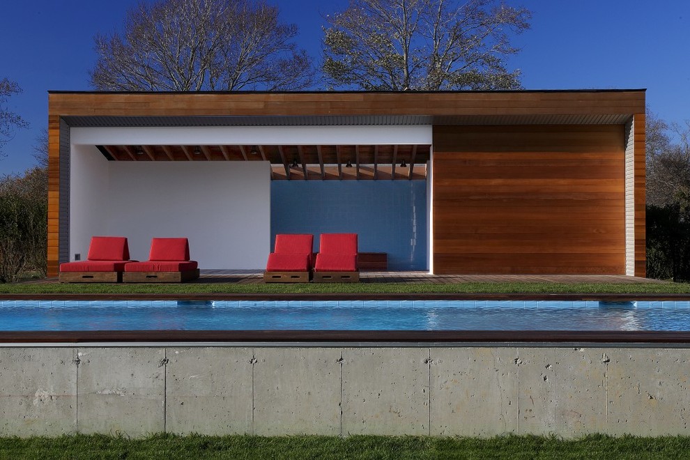 Foto di una grande piscina monocorsia moderna rettangolare dietro casa con una dépendance a bordo piscina e pedane