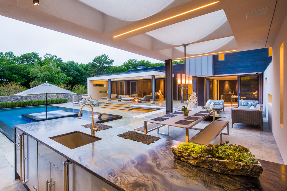 This is an example of a large contemporary back patio in New York with a water feature.