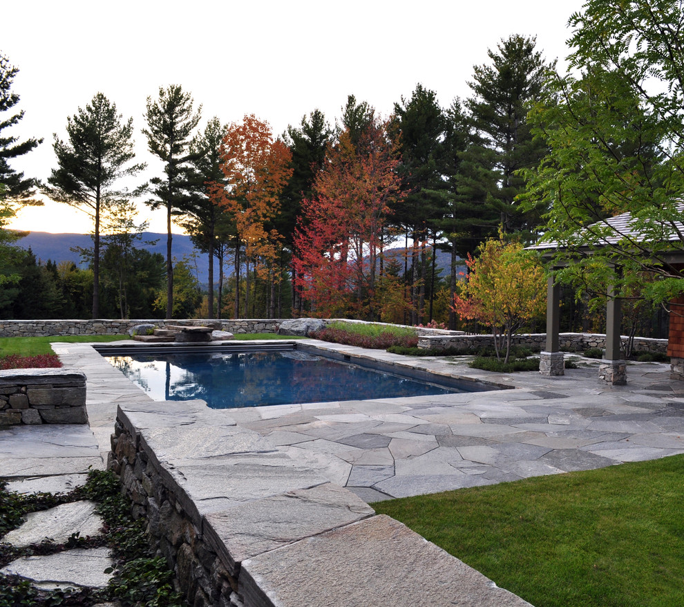 Immagine di una piscina tradizionale rettangolare con pavimentazioni in pietra naturale
