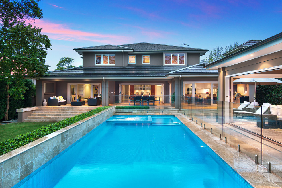 Immagine di una piscina monocorsia classica rettangolare dietro casa con una vasca idromassaggio e piastrelle