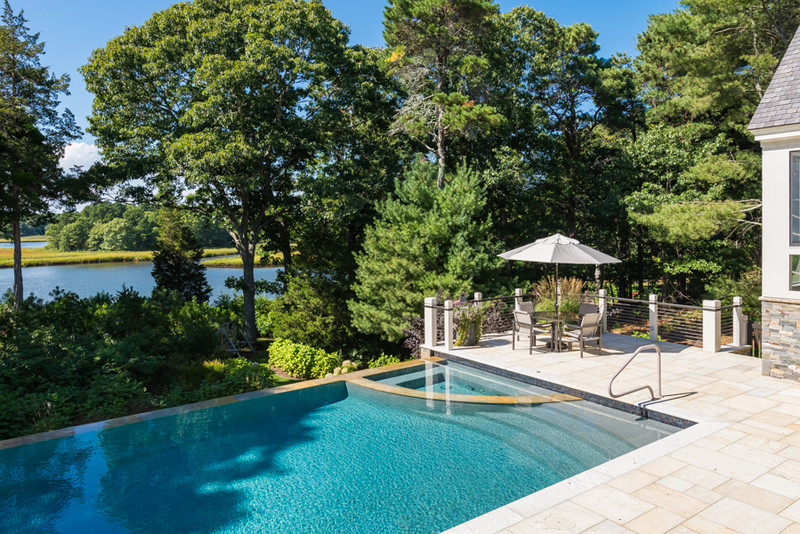 Mid-sized elegant backyard tile and rectangular infinity hot tub photo in Boston