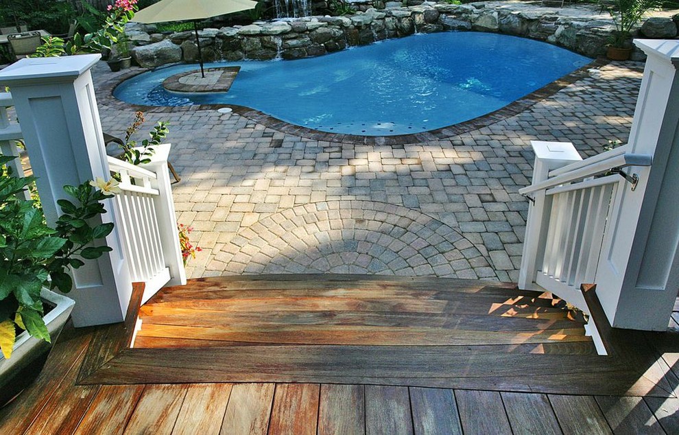 Aménagement d'une piscine naturelle et arrière craftsman de taille moyenne et sur mesure avec des pavés en pierre naturelle.