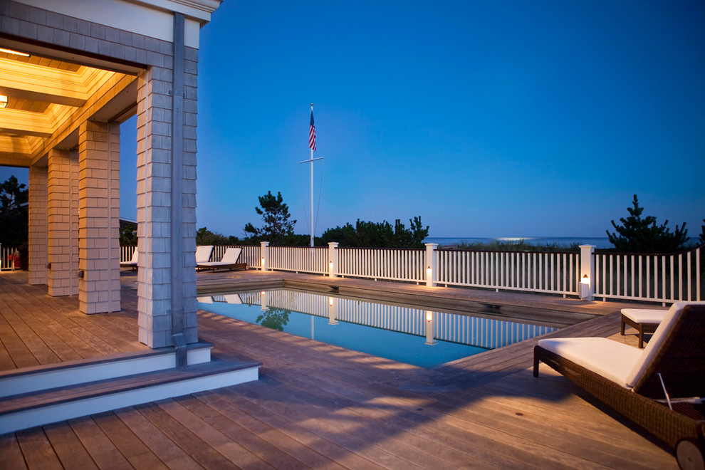 Cette photo montre une piscine arrière bord de mer rectangle avec une terrasse en bois.