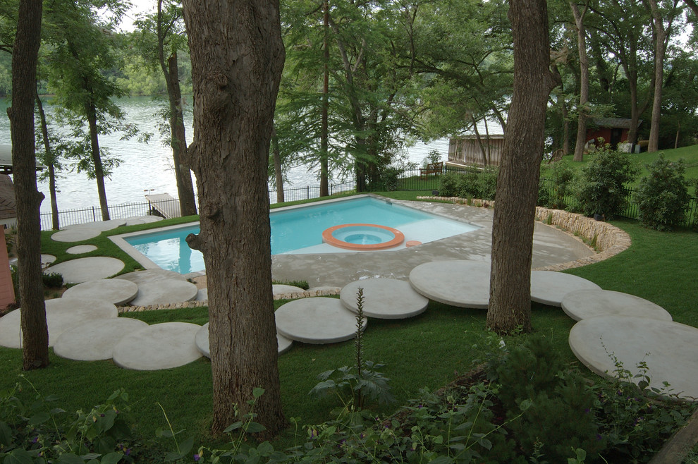 Стильный дизайн: большой прямоугольный бассейн на заднем дворе в стиле фьюжн с покрытием из бетонных плит и джакузи - последний тренд