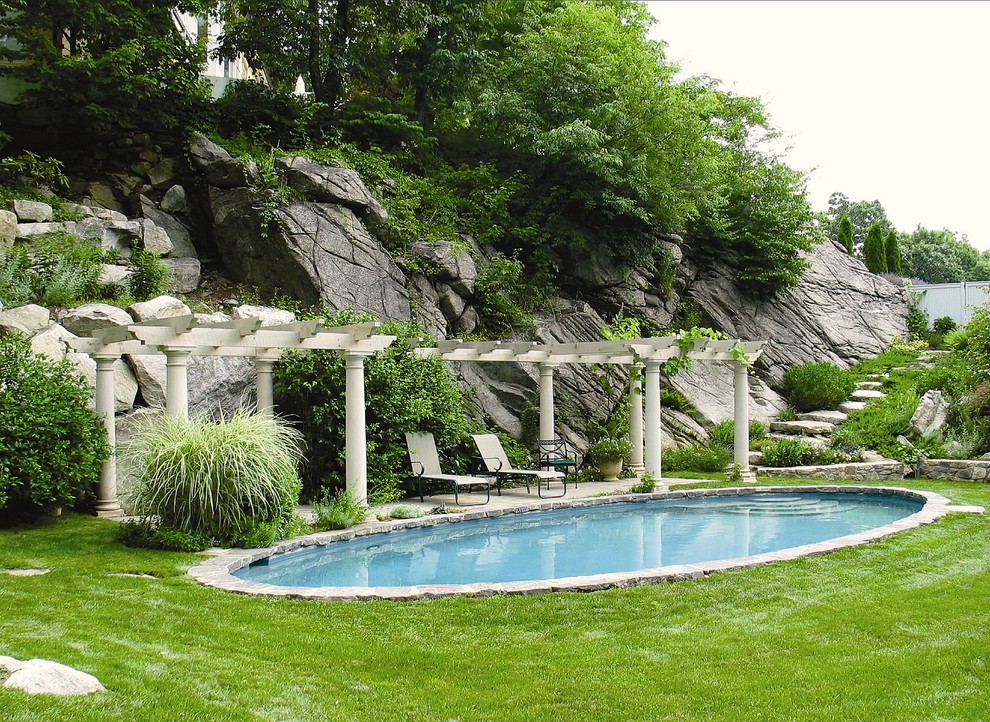 Großer Klassischer Schwimmteich hinter dem Haus in Nierenform mit Natursteinplatten und Wasserspiel in New York