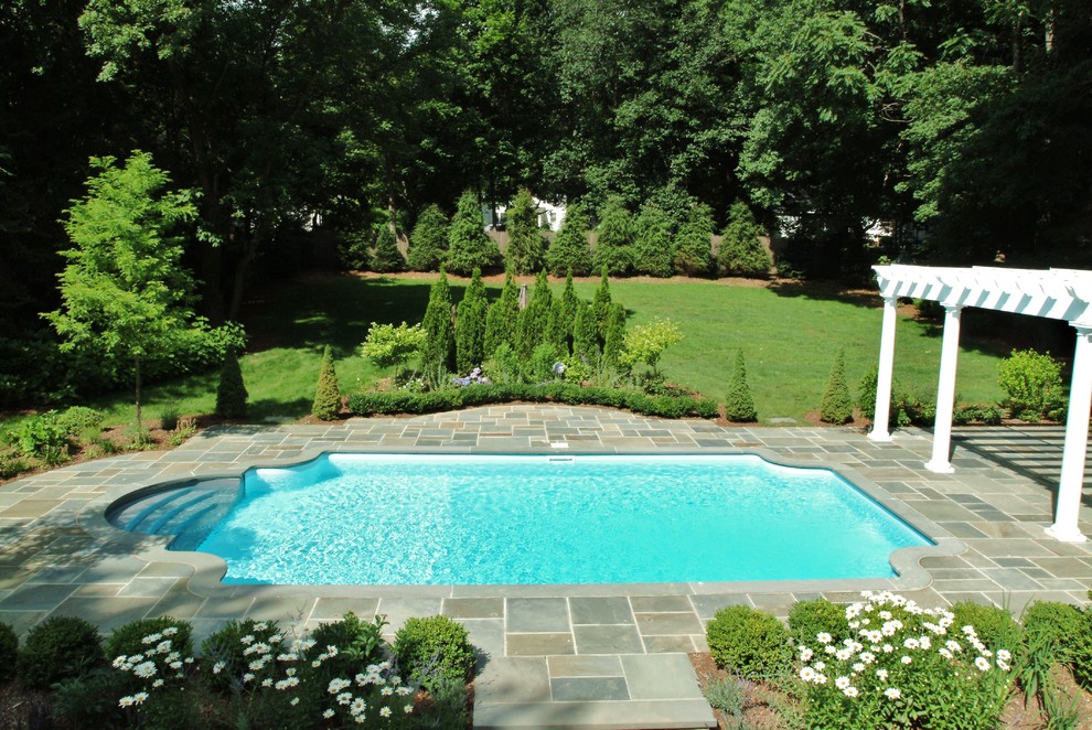 Großer Klassischer Schwimmteich hinter dem Haus in rechteckiger Form mit Wasserspiel und Natursteinplatten in New York