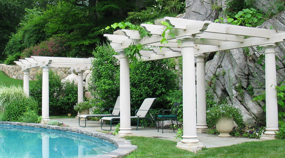 Ejemplo de piscina con fuente natural tradicional grande tipo riñón en patio trasero con adoquines de piedra natural