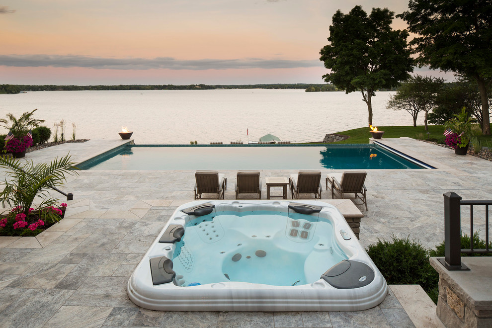 Ispirazione per una piscina monocorsia costiera rettangolare dietro casa con una vasca idromassaggio e pavimentazioni in pietra naturale