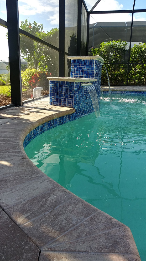 Ejemplo de piscina con fuente natural moderna de tamaño medio a medida en patio trasero con suelo de baldosas