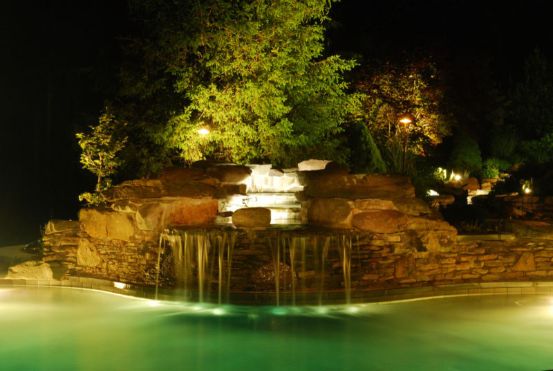 Esempio di un'ampia piscina naturale contemporanea personalizzata dietro casa con fontane