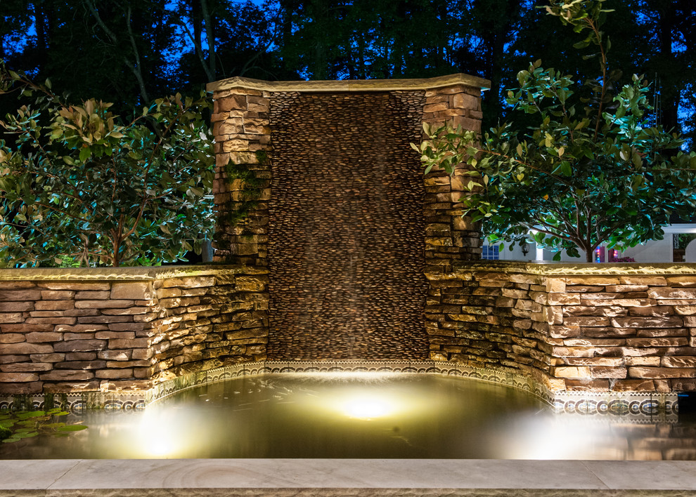 Imagen de piscina con fuente de estilo americano pequeña a medida en patio trasero con adoquines de piedra natural