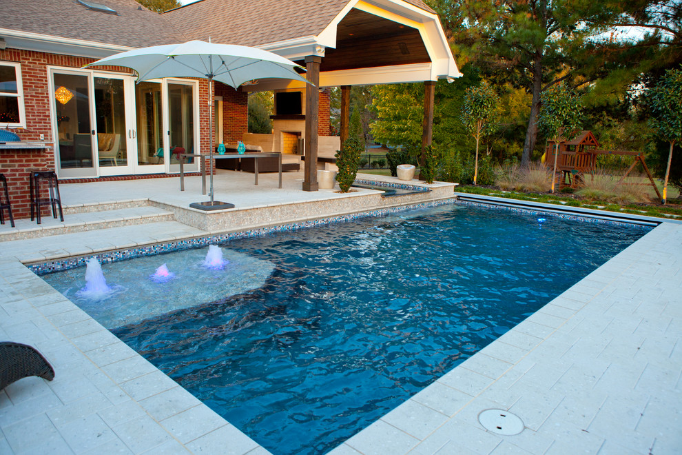 Ejemplo de piscinas y jacuzzis alargados tradicionales renovados de tamaño medio rectangulares en patio trasero con suelo de baldosas