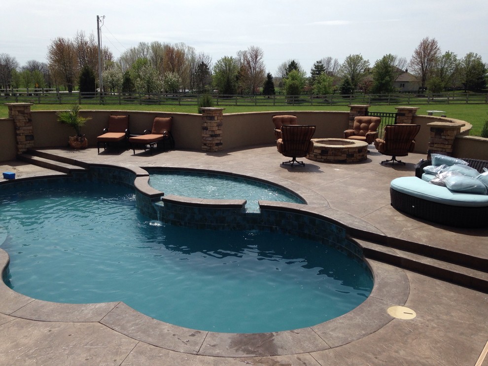 Large elegant backyard concrete and custom-shaped lap hot tub photo in Kansas City