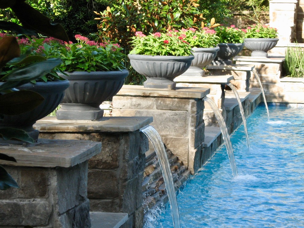Photo of a medium sized traditional back rectangular lengths swimming pool in Houston with a water feature and stamped concrete.