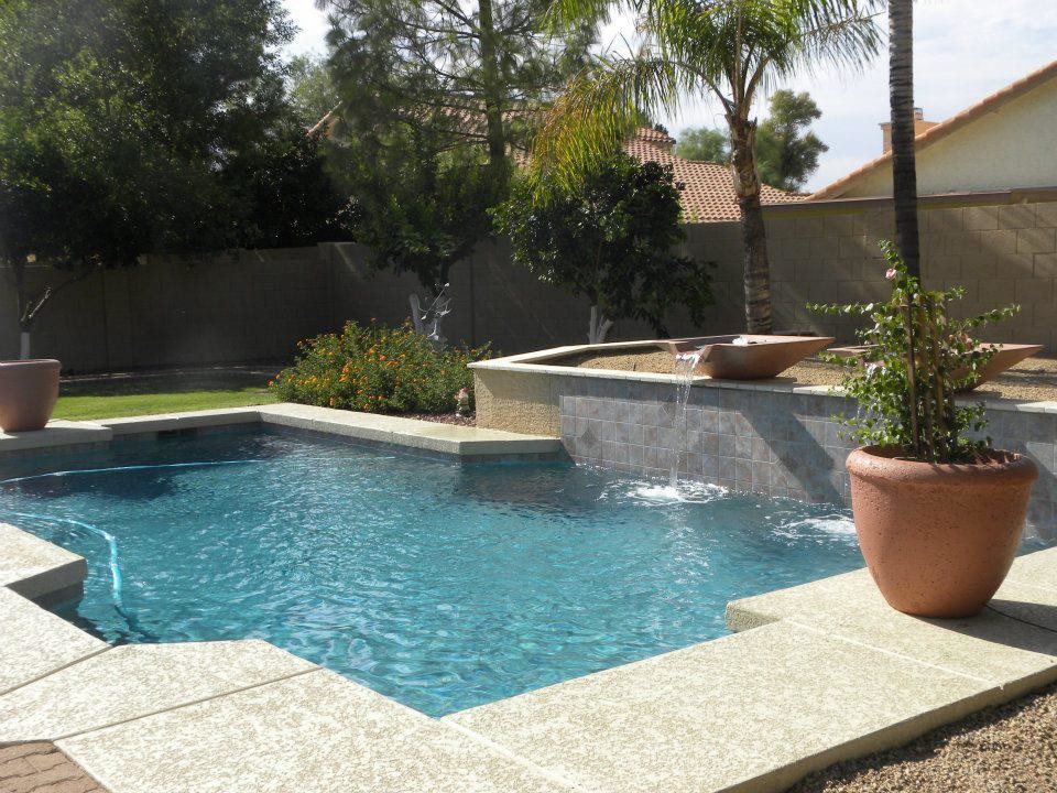 Diseño de piscina con fuente actual de tamaño medio rectangular en patio trasero con entablado