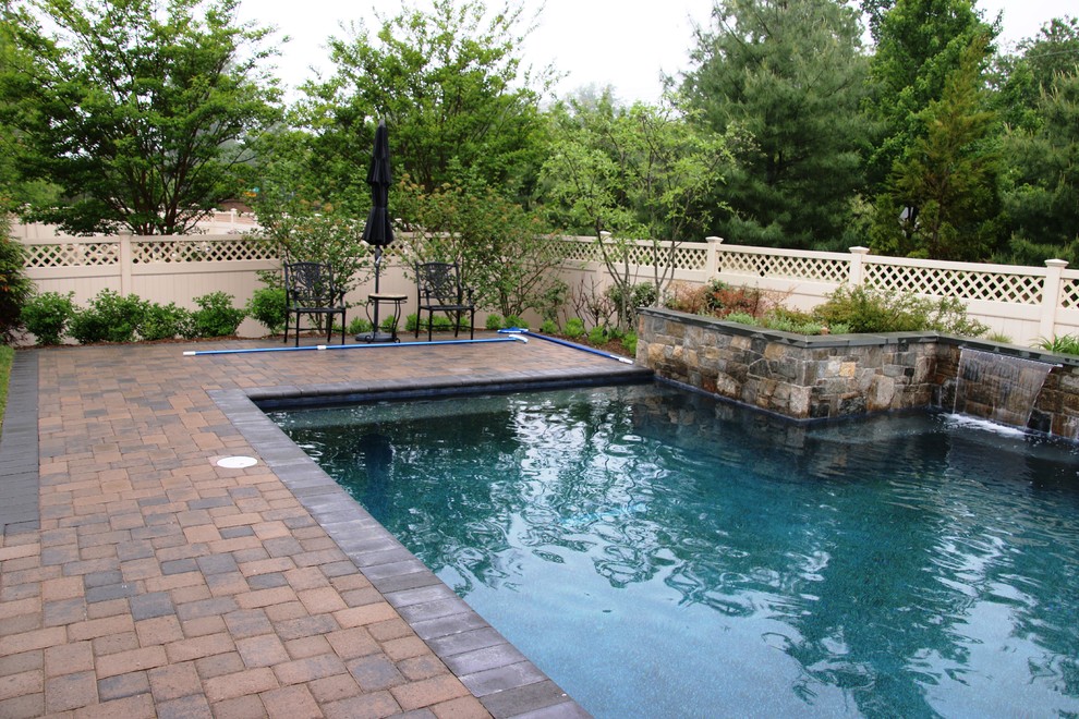 Ispirazione per una piscina tradizionale rettangolare di medie dimensioni e dietro casa con fontane e pavimentazioni in mattoni