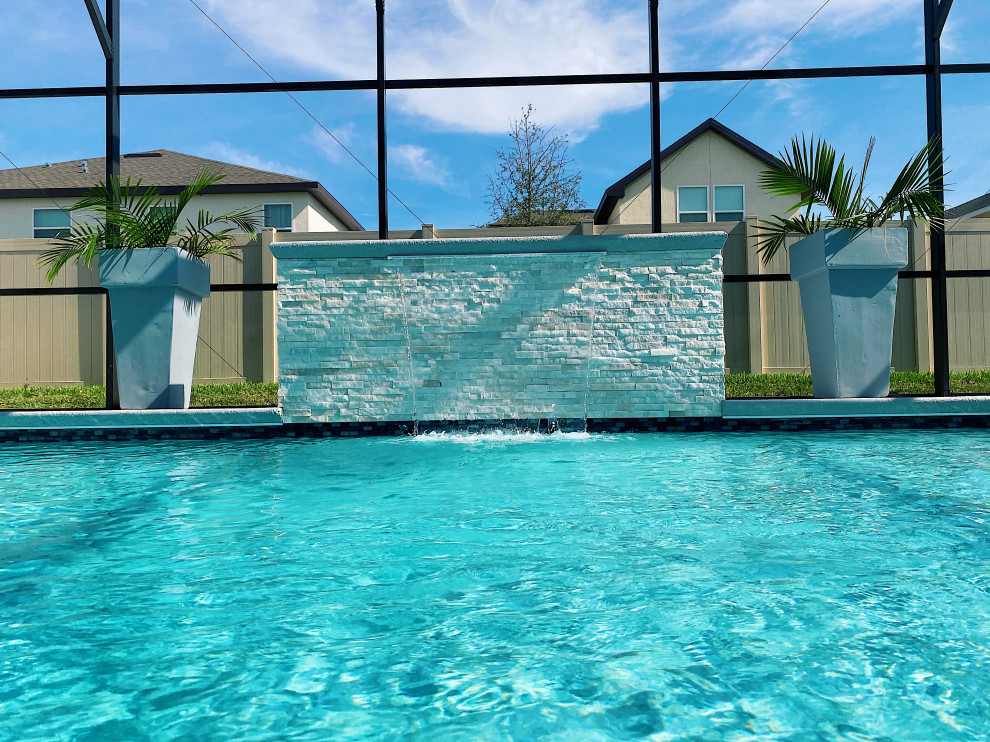 Стильный дизайн: прямоугольный бассейн среднего размера на заднем дворе в стиле модернизм с фонтаном и покрытием из декоративного бетона - последний тренд