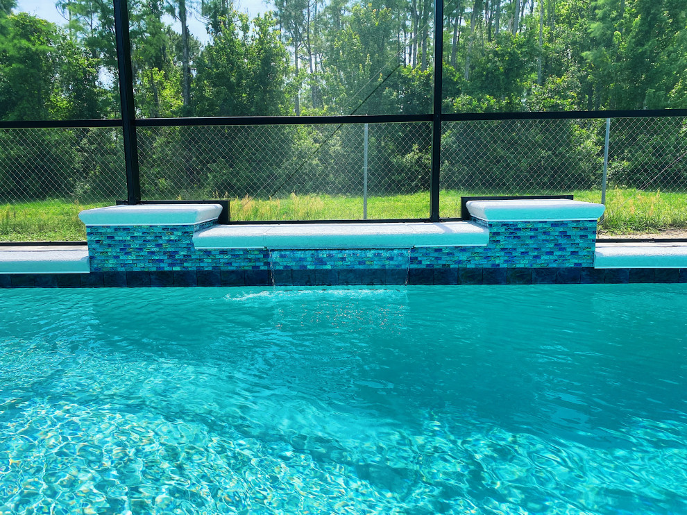 Ispirazione per una piscina minimalista rettangolare di medie dimensioni e dietro casa con fontane e pavimentazioni in mattoni