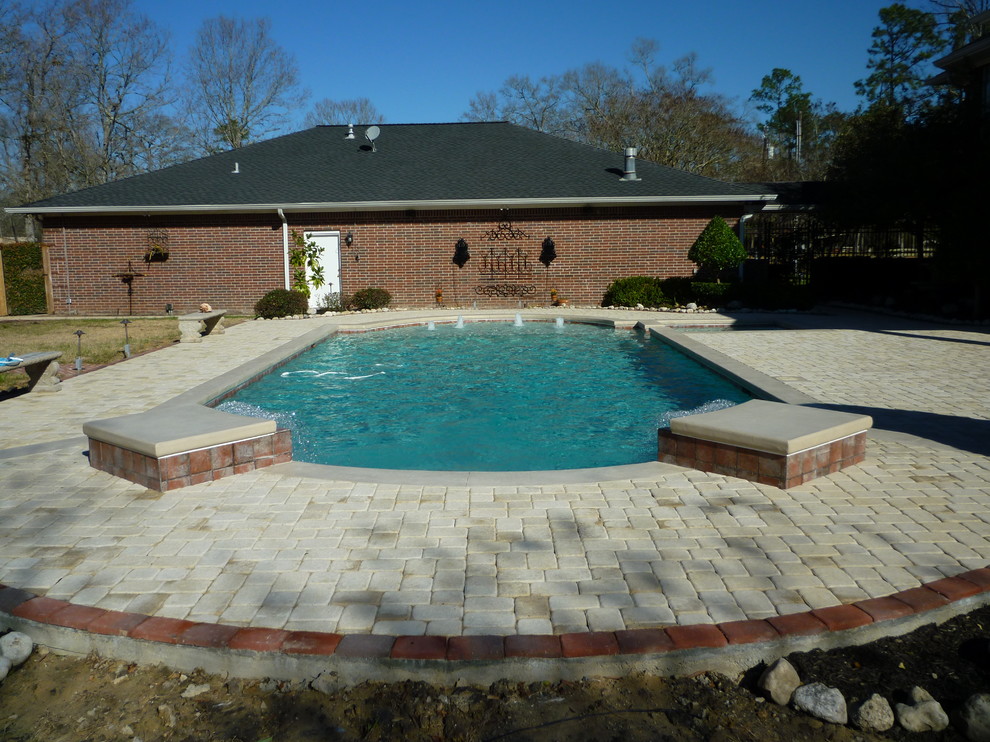 Exempel på en modern anpassad pool, med en fontän och marksten i betong