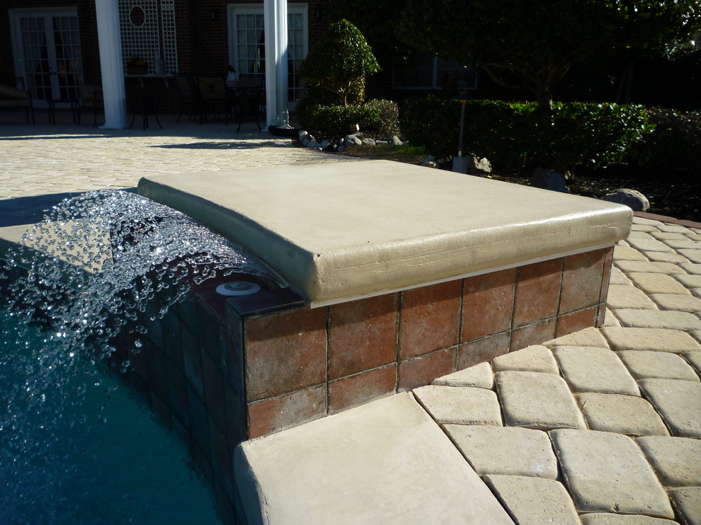 Trendy concrete paver and custom-shaped pool fountain photo in Houston