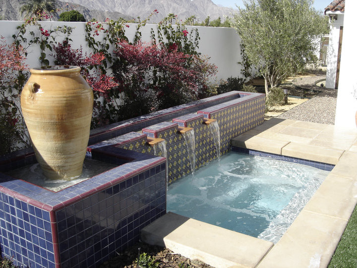 Hot tub - mid-sized mediterranean backyard stone and rectangular lap hot tub idea in Orange County