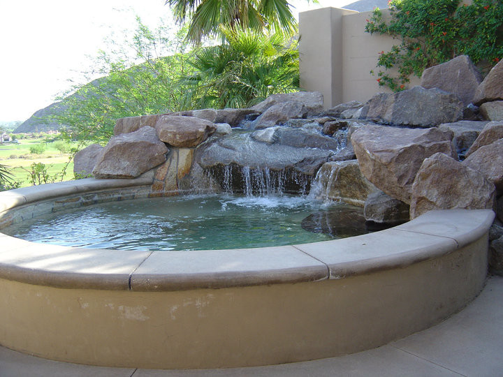 На фото: маленький естественный бассейн произвольной формы на заднем дворе в средиземноморском стиле с покрытием из каменной брусчатки и джакузи для на участке и в саду с