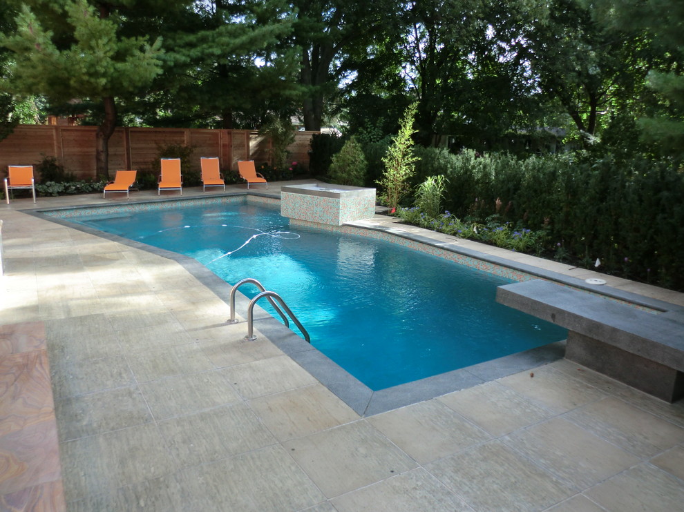 Ispirazione per una piscina fuori terra minimalista personalizzata di medie dimensioni e dietro casa con fontane e pavimentazioni in pietra naturale