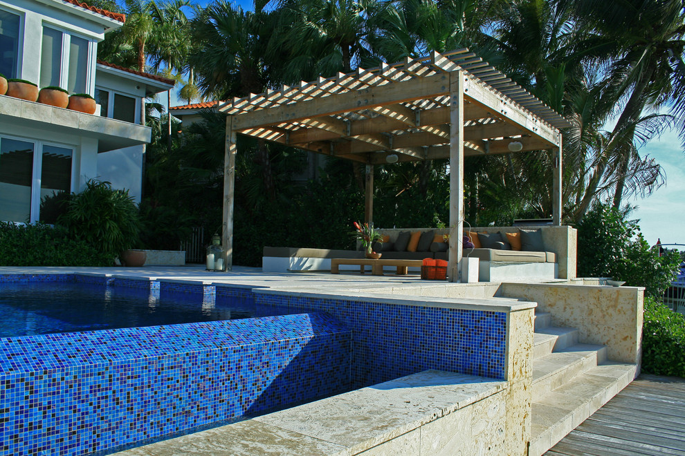 Großer, Gefliester Moderner Infinity-Pool hinter dem Haus in rechteckiger Form mit Wasserspiel in Miami