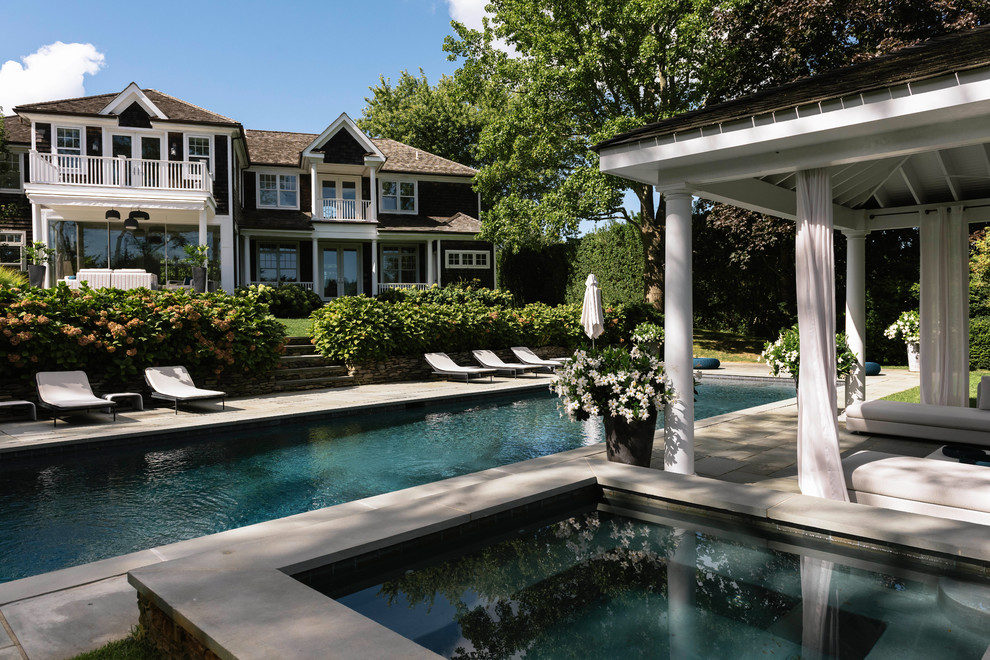Esempio di una piscina monocorsia classica rettangolare dietro casa con una vasca idromassaggio