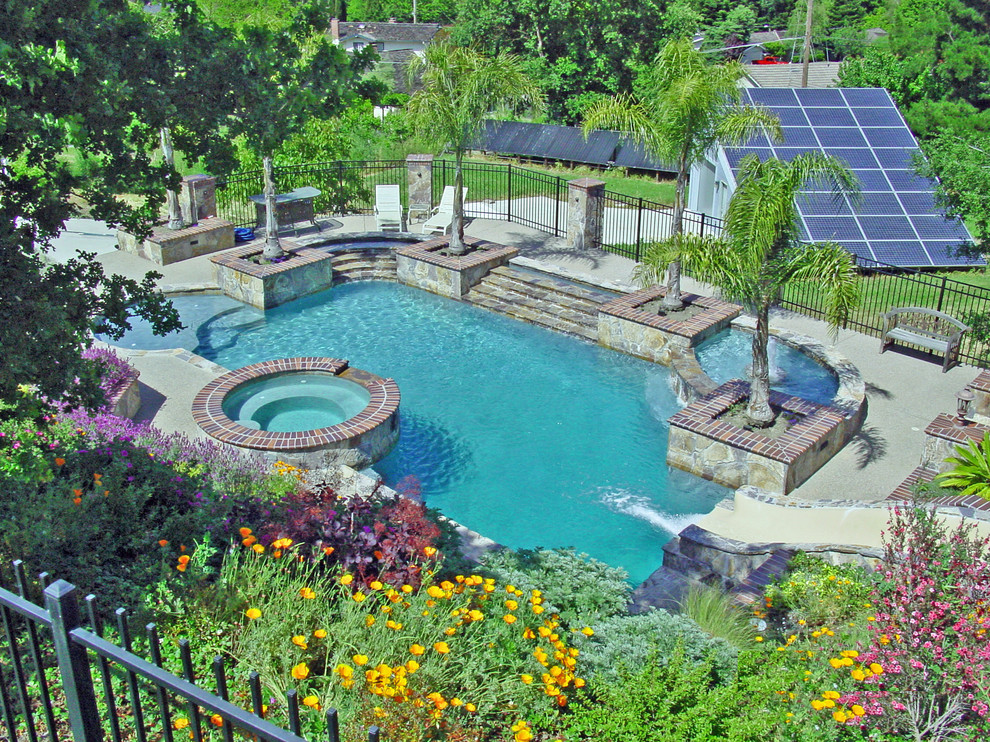Ejemplo de piscina con tobogán alargada mediterránea de tamaño medio rectangular en patio trasero con suelo de hormigón estampado