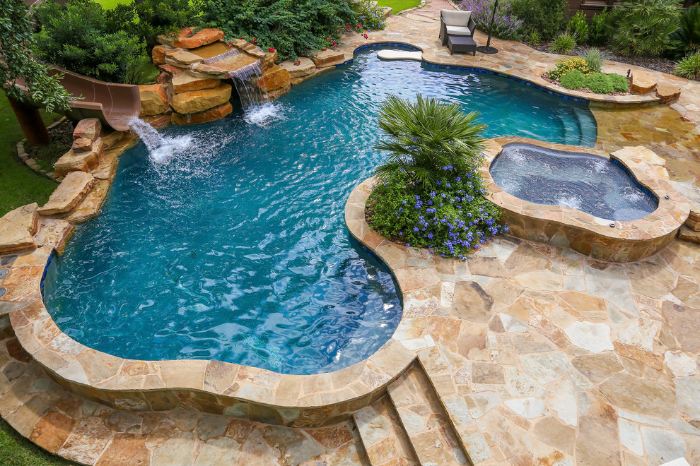 Réalisation d'une grande piscine naturelle et arrière chalet sur mesure avec des pavés en pierre naturelle et un bain bouillonnant.