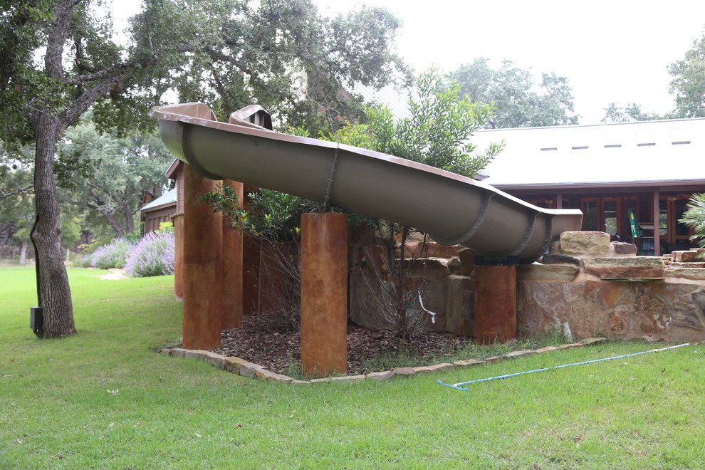 Hot tub - large rustic backyard stone and custom-shaped natural hot tub idea in Austin