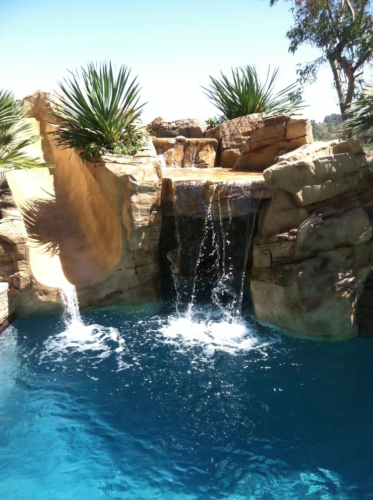 Exemple d'une piscine naturelle et arrière exotique de taille moyenne avec un toboggan.