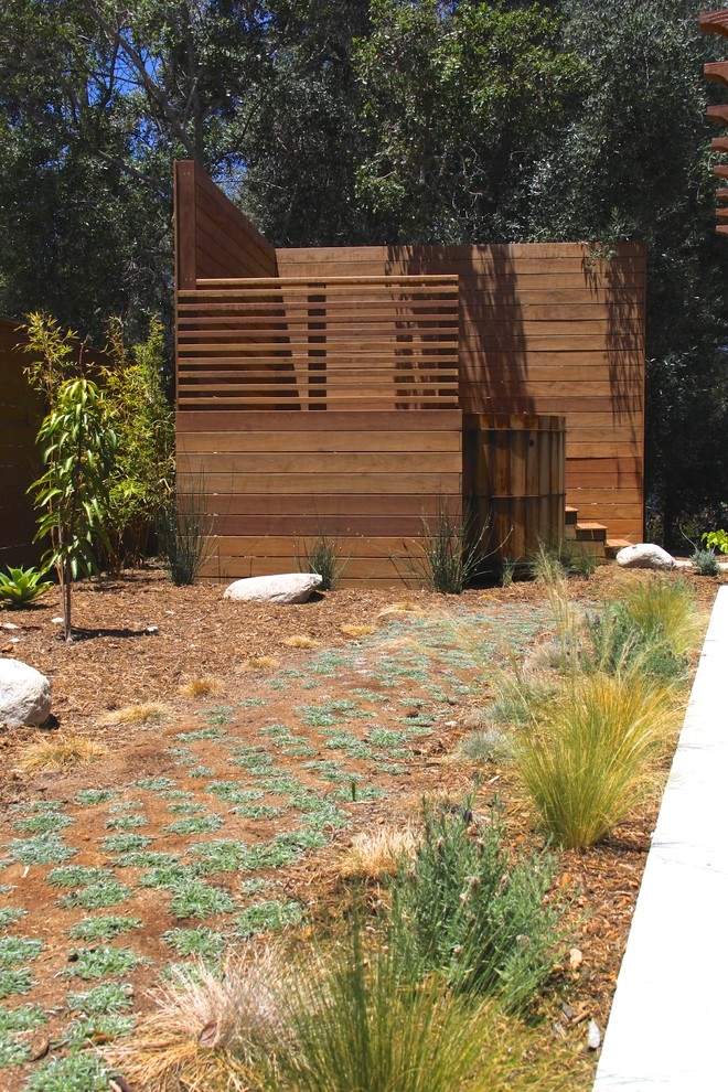 Immagine di una piscina fuori terra design rotonda di medie dimensioni e dietro casa con una vasca idromassaggio e pavimentazioni in pietra naturale