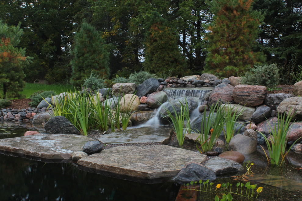 Imagen de jardín rústico de tamaño medio en patio trasero con fuente y entablado