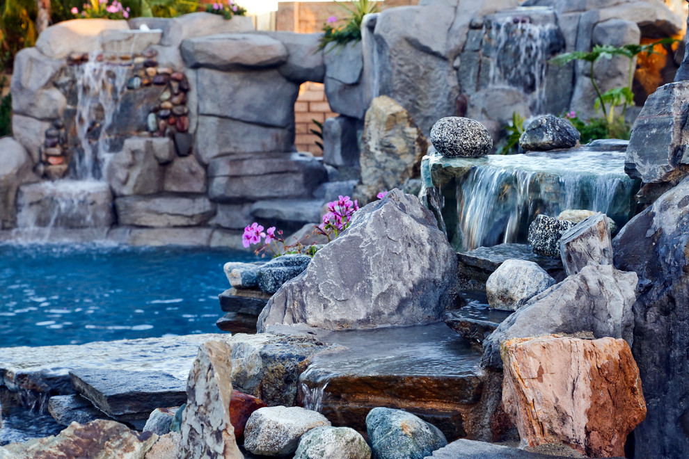 Foto de piscinas y jacuzzis naturales tropicales grandes a medida en patio trasero con adoquines de piedra natural