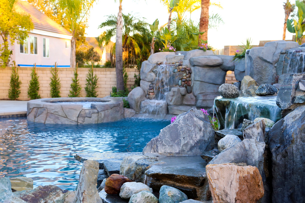 Imagen de piscinas y jacuzzis naturales exóticos grandes a medida en patio trasero con adoquines de piedra natural