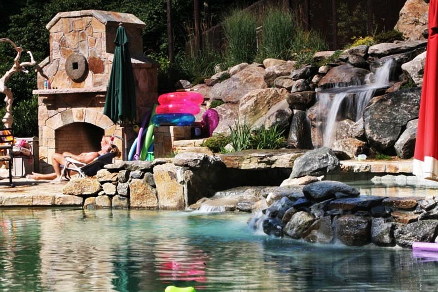 Esempio di una piscina moderna personalizzata di medie dimensioni e dietro casa con fontane e cemento stampato
