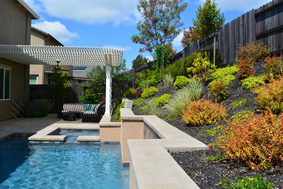 Small trendy backyard stamped concrete and rectangular pool fountain photo in Sacramento