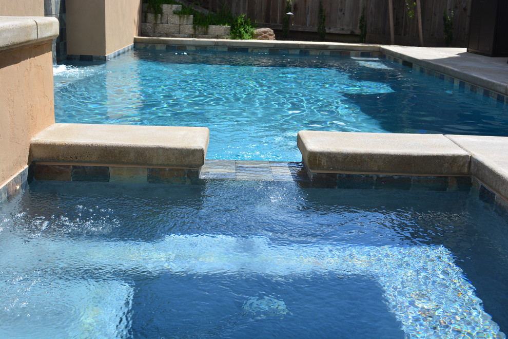 Design ideas for a small contemporary back rectangular swimming pool in Sacramento with a water feature and stamped concrete.