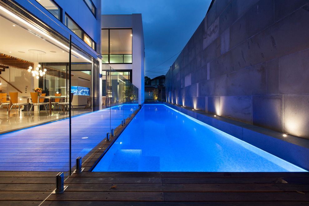 Ejemplo de piscina alargada actual rectangular en patio trasero con entablado