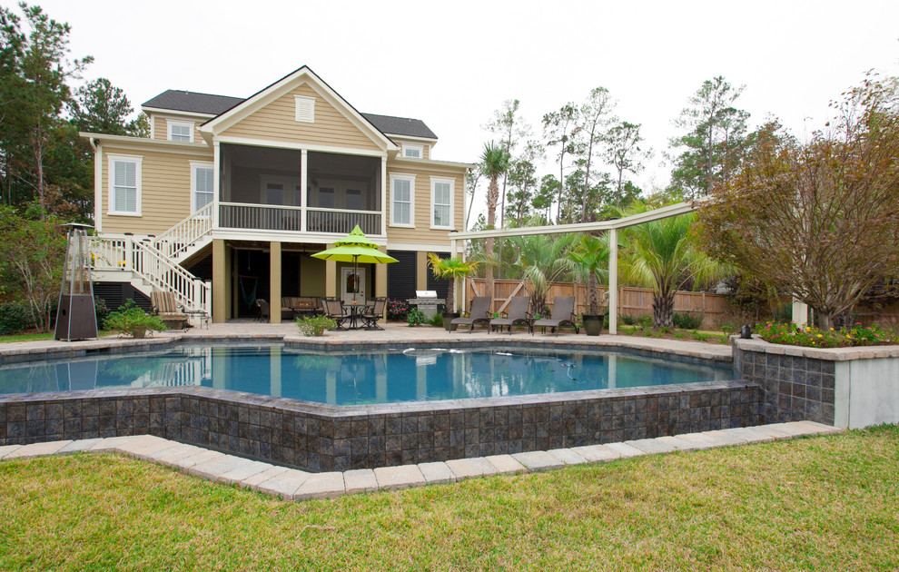 Foto de piscina con fuente infinita clásica grande a medida en patio trasero con adoquines de ladrillo
