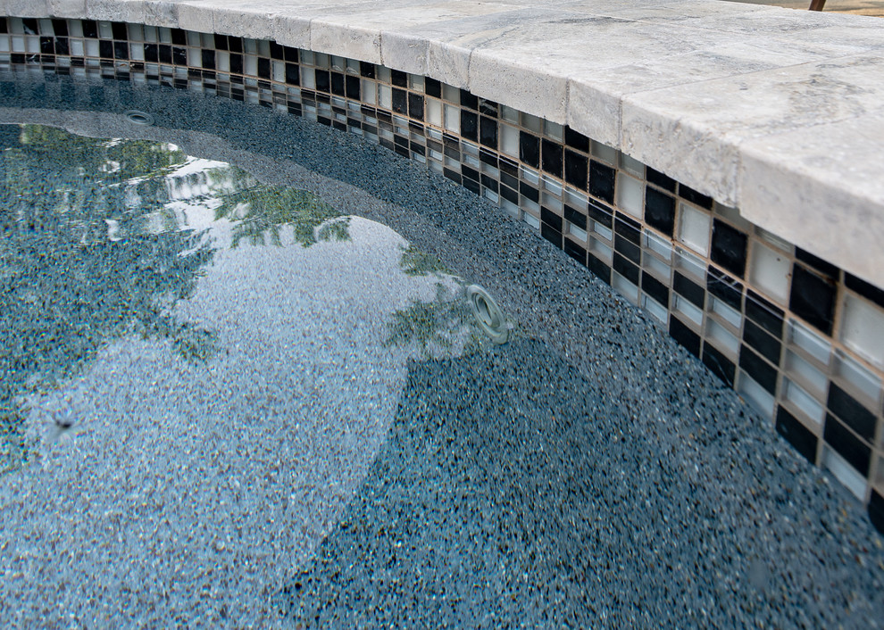 Exemple d'une piscine naturelle et arrière exotique de taille moyenne et sur mesure avec un bain bouillonnant et une terrasse en bois.