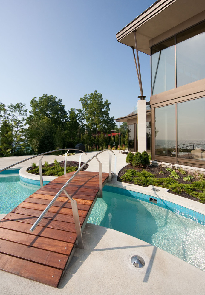 На фото: бассейн произвольной формы в современном стиле с покрытием из бетонных плит