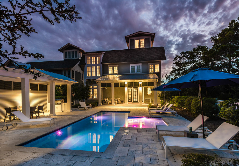 This is an example of an expansive shabby-chic style courtyard custom shaped swimming pool in Other with natural stone paving.