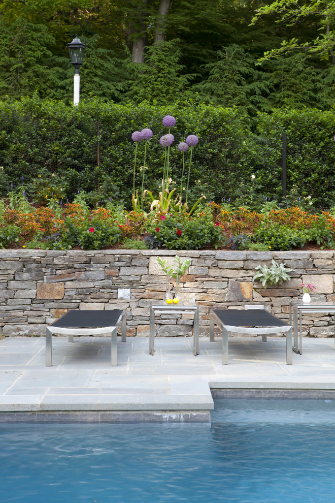 Immagine di una piscina monocorsia tradizionale personalizzata di medie dimensioni e dietro casa con pavimentazioni in pietra naturale