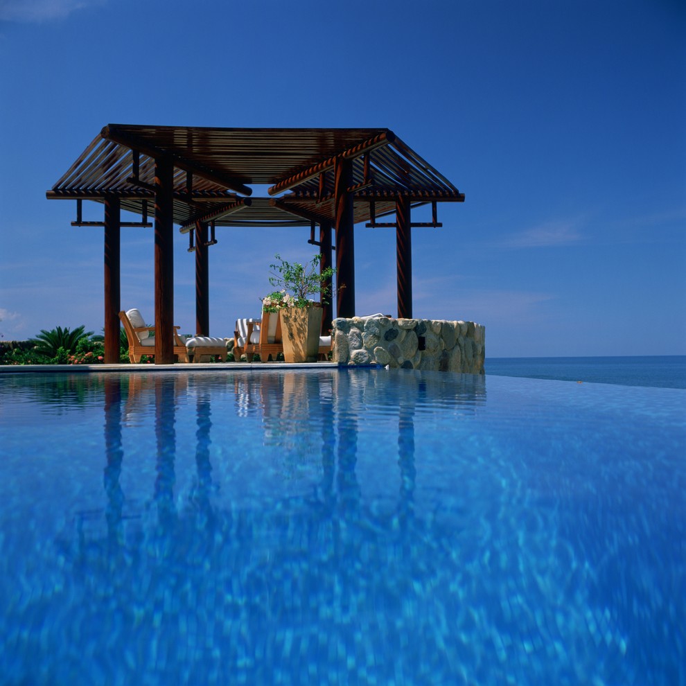Imagen de piscina con fuente infinita exótica grande rectangular en patio trasero