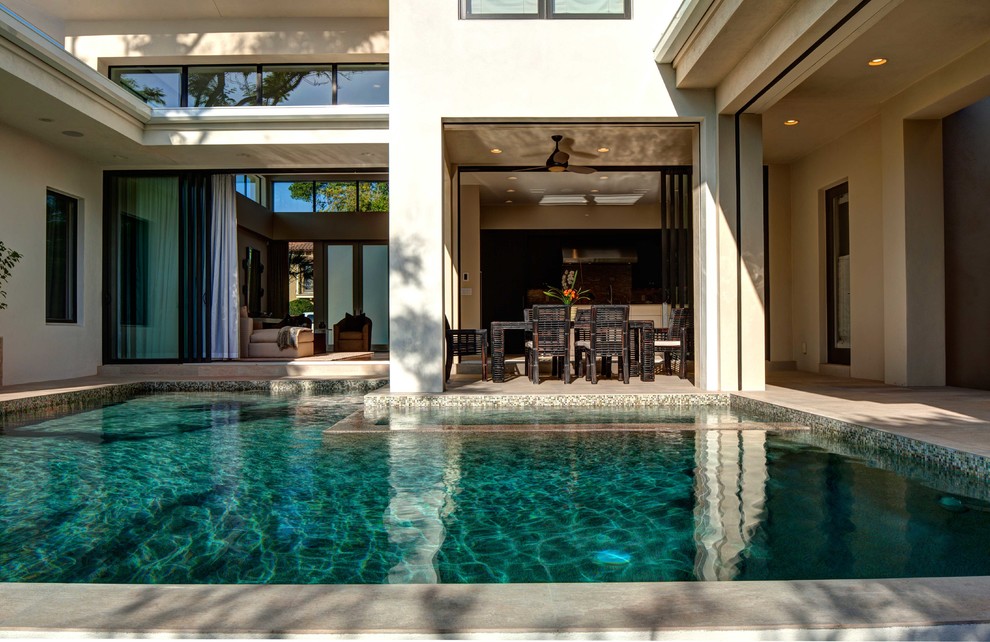 Modelo de casa de la piscina y piscina moderna grande a medida en patio trasero con losas de hormigón